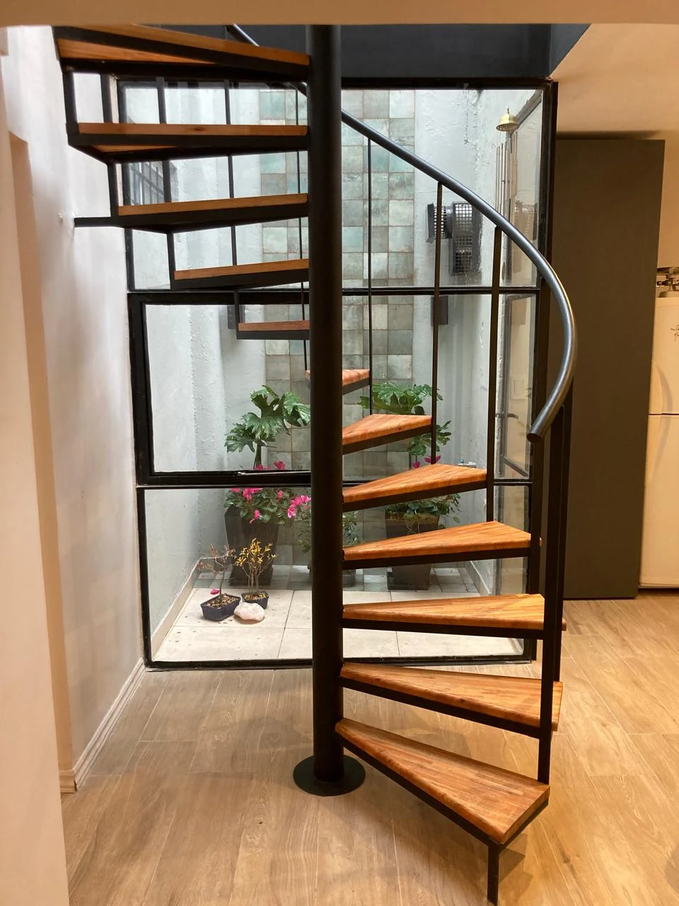 Escalera de madera frente al patio vidriado